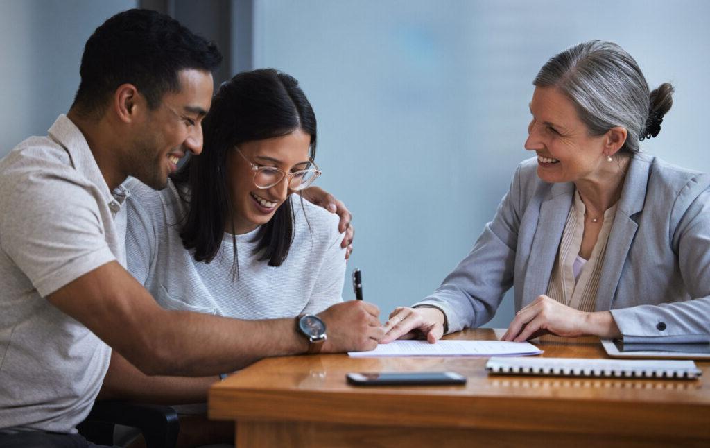 A couple talks with a credit union representative about refinancing their auto loan.